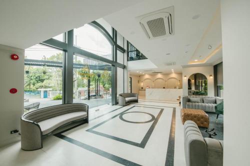 uma sala de estar cheia de mobiliário e uma grande janela em Carrara Hotel Hatyai em Hat Yai