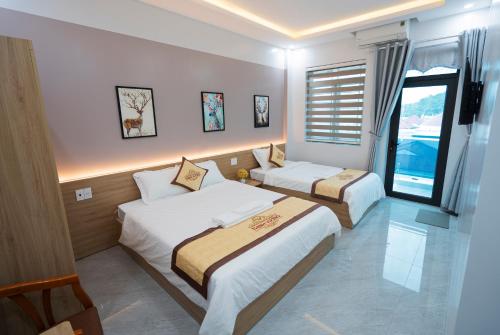 ein Hotelzimmer mit 2 Betten und einem Fenster in der Unterkunft HoTel Thịnh Vượng in Diện Biên Phủ