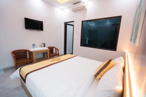 ein Schlafzimmer mit einem großen Bett und einem TV an der Wand in der Unterkunft HoTel Thịnh Vượng in Diện Biên Phủ