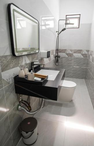 a bathroom with a sink and a mirror and a toilet at Thịnh Vượng HoTel in Diện Biên Phủ