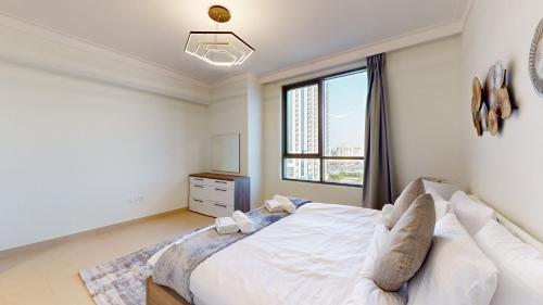 1 dormitorio con cama blanca y ventana en Primestay - Creek Residences South Tower 3, Creek Harbour en Dubái