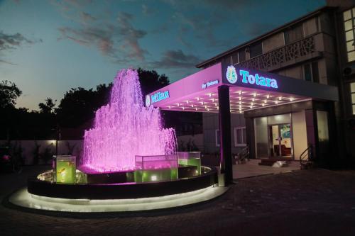 una fontana di fronte a un edificio di Hotel Totara a Dar es Salaam