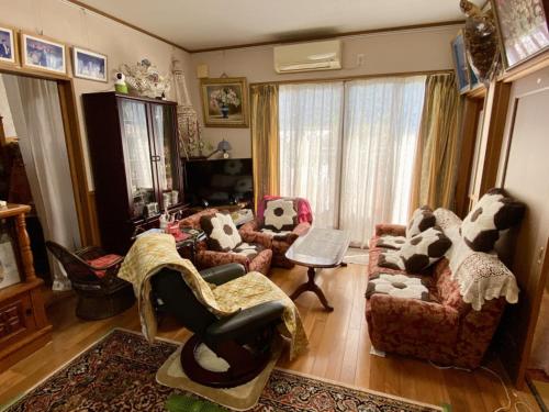 a living room with couches and chairs in a room at Guest in Shallman in Amami