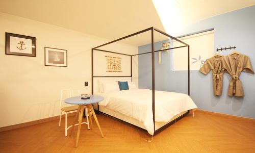 a bedroom with a bed and a table and a clothes rack at Iksan 4 Seasons Hotel in Iksan