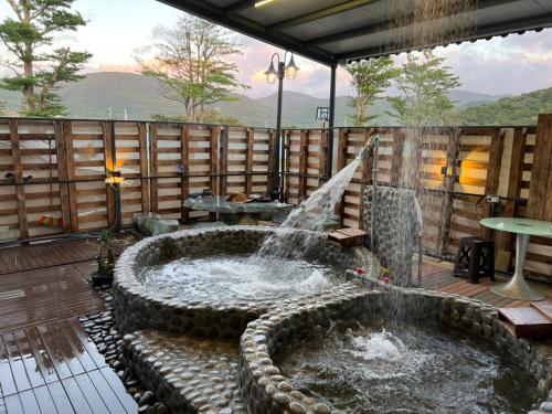 a water fountain on a deck with a table at XingYe B&B in Checheng