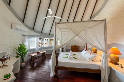 een slaapkamer met een hemelbed bij Nika Island Resort & Spa, Maldives in Nika Island