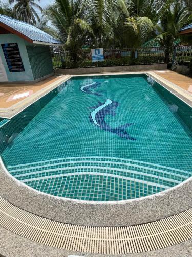 a large blue swimming pool with a tile floor at Blue Beach Bungalow in Bang Saphan Noi