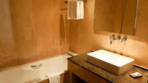 uma casa de banho com um lavatório e uma banheira em Royal Decameron Tafoukt Beach Resort & Spa - All Inclusive em Agadir