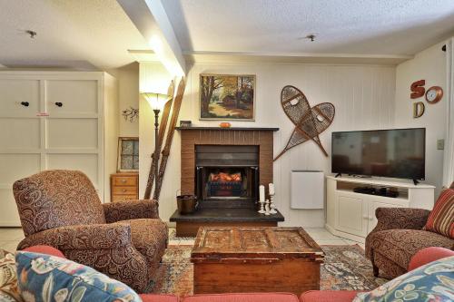 a living room with a fireplace and a tv at Mountain Green Condo 3A10 condo in Killington