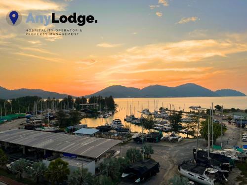 a marina at sunset with mountains in the background at AnyLodge Waterfront Marina Island Pangkor in Lumut