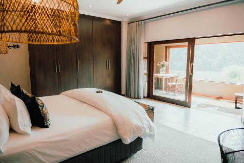 a bedroom with a large bed and a large window at Bambuu Lakeside Lodge in Hazyview