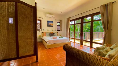 - une chambre avec un lit et un balcon dans l'établissement Tropical garden, à Phuket