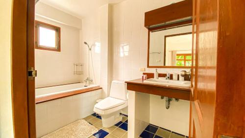 Un baño con inodoro, lavabo y espejo. en Tropical garden, en Phuket