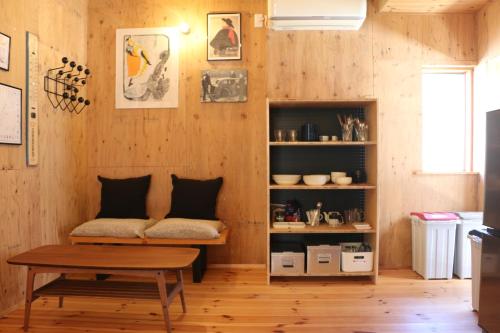 a living room with a bench and a table at Hostel Fish in a River in Takayama