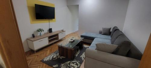 a living room with a couch and a tv at Stan na dan - Apartmani Q in Doboj