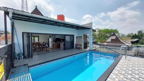 a villa with a swimming pool and a house at Pool Villa Saung Suluh in Purwokerto