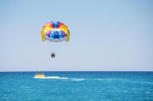 a colorful parachute flying over the ocean with a boat at M Social Hotel Phuket in Patong Beach