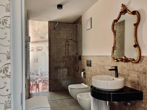 uma casa de banho com um lavatório, um WC e um espelho. em Haus Noldin - historische Herberge - dimora storica em Salorno