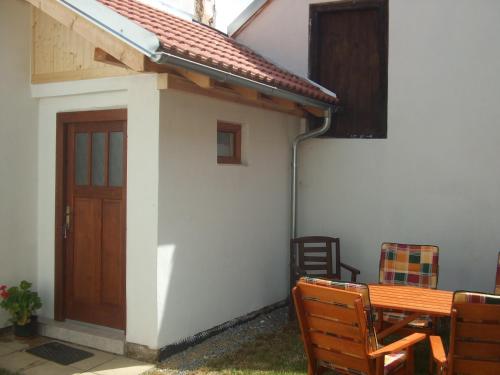 a small house with a wooden door and a table at Apartmán Mirkovice in Mírkovice