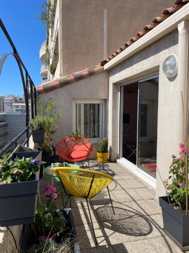 un patio con mesa, sillas y macetas en Colourful loft in Marseille, en Marsella