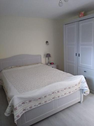 a bedroom with a white bed and a closet at AU COEUR DES CHATEAUX in Ballan-Miré