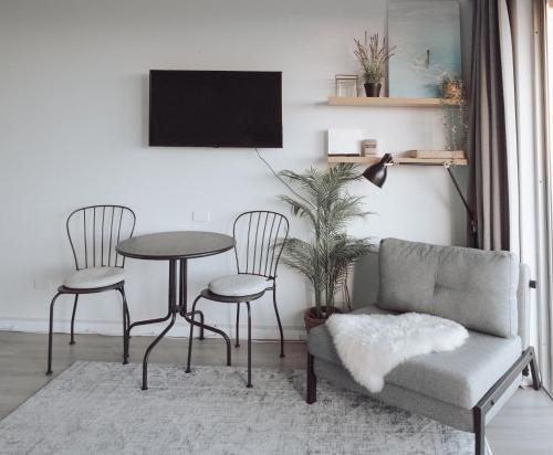 a living room with a couch and a table and chairs at Cosy studio with a big view in Sydney
