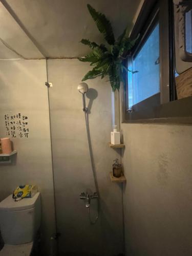 baño con ducha, aseo y ventana en 白紙寓所blank slate B&B-鄰近夜市四人包棟 en Luodong