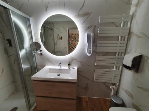 y baño con lavabo y espejo. en Logis Hôtel Restaurant L'Odyssée Champêtre, en Le Lude