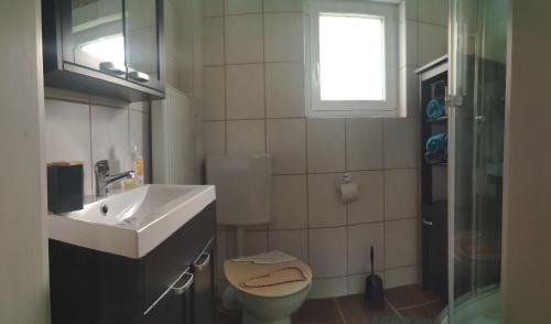 bagno con lavandino, servizi igienici e finestra di Bayrisch, ländlich, gemütlich a Burglengenfeld