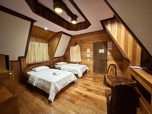 a room with two beds and a staircase at MAGMAI HOMESTAY & TOWER in Tak