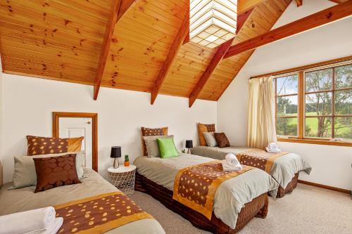 Schlafzimmer mit 3 Betten und Holzdecke in der Unterkunft Perfect Getaway in Phillip Island in Ventnor
