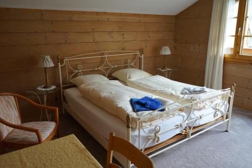 a bedroom with a white bed with a wooden wall at Haus Solvay mit freier Matterhornsicht in Zermatt