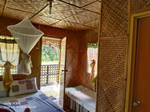 a room with a bed and a door with a window at Shirley's Cottage - Pamilacan Island in Baclayon