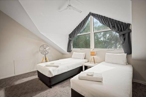 um quarto com 2 camas e uma janela em Sandblu: Resort Villa on the Beach em Broadwater