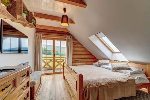 - une chambre avec un lit dans une pièce dotée d'une fenêtre dans l'établissement Domek w Górach z Balią, à Zawoja