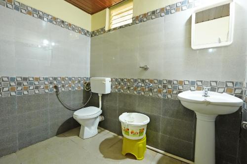a bathroom with a toilet and a sink at Leisure Homestay - Pool, Food, Estate in Chikmagalūr