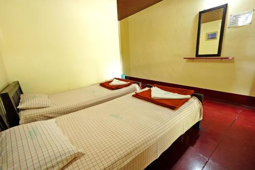 two beds sitting next to each other in a room at Leisure Homestay - Pool, Boating, Zipline, Home Food, Estate in Chikmagalūr
