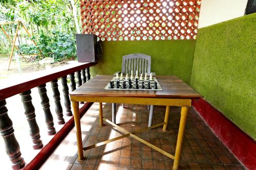 a chair sitting on a table on a balcony at Leisure Homestay - Pool, Boating, Zipline, Home Food, Estate in Chikmagalūr