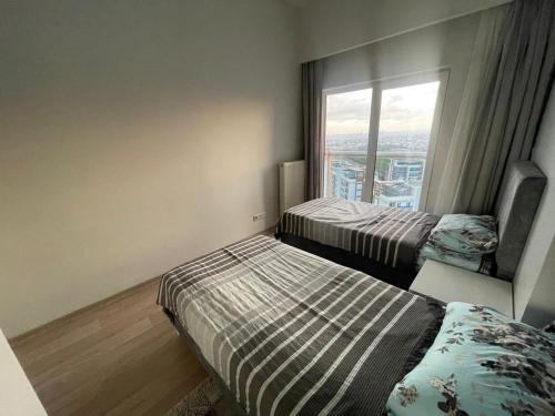 2 camas en una habitación con ventana en شقة للإيجار السياحي في باشاك شهير سوبر ديلوكس, en Basaksehir