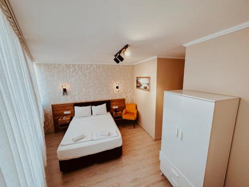 een kleine slaapkamer met een bed en een koelkast bij Punta Vista Otel in Izmir