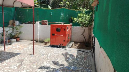 a red appliance sitting next to a green wall at Paradise corner in Puducherry