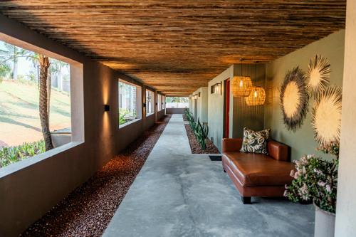 a hallway of a house with a couch and windows at Bambuu Lakeside Lodge in Hazyview