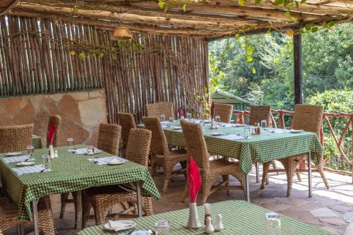 an outdoor dining area with tables and chairs at Sentrim Mara Lodge in Ololaimutiek