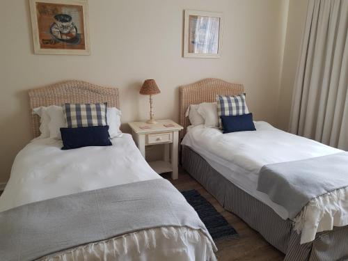 dos camas sentadas una al lado de la otra en un dormitorio en Lodge 90 - Pinnacle Point Estate, en Mossel Bay