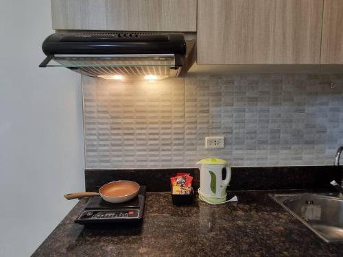 a kitchen counter top with a sink and a stove at Chic Studio 5 min walk to Cebu Business Park/Ayala in Cebu City