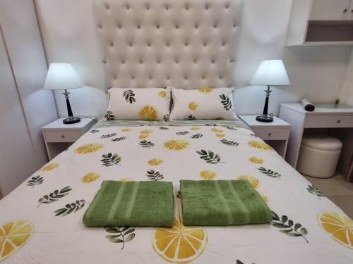 a bedroom with a bed with two green towels on it at Chic Studio 5 min walk to Cebu Business Park/Ayala in Cebu City