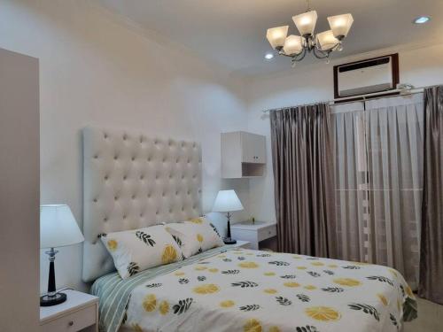 a bedroom with a bed with a yellow and white comforter at Chic Studio 5 min walk to Cebu Business Park/Ayala in Cebu City