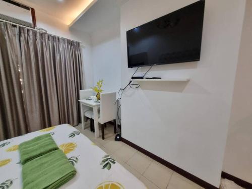 a room with a bed and a flat screen tv at Chic Studio 5 min walk to Cebu Business Park/Ayala in Cebu City