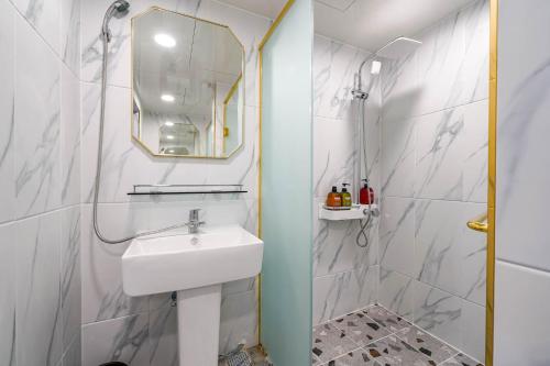 Oops Hotel في بوسان: حمام أبيض مع حوض ومرآة