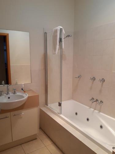 a bathroom with a bath tub and a sink at The Lakes Apartments in Lakes Entrance